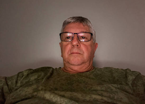 Senior Caucasian man watching laptop in basement