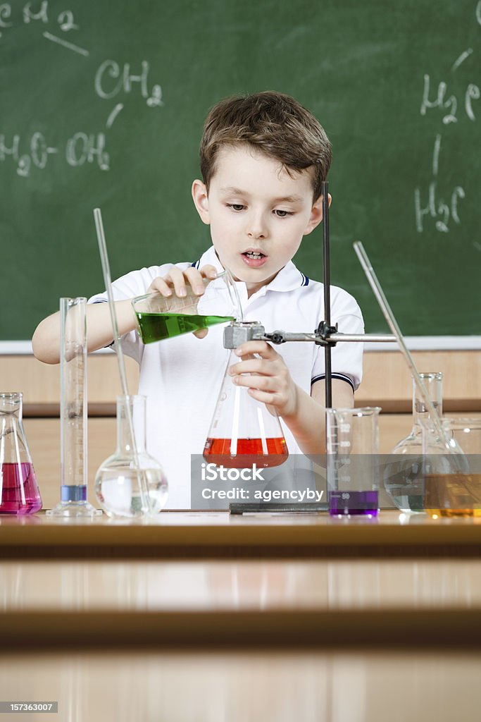 Little chemist conducts an experiment Little chemist holds scientific experiment Activity Stock Photo