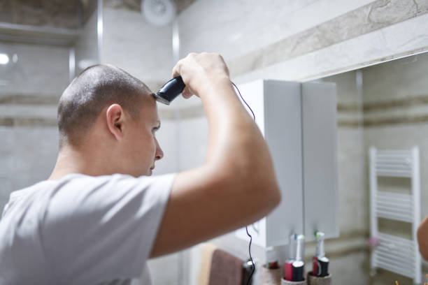 istock Male Trimming Hair And Looking At Reflection In Mirror 1573636445