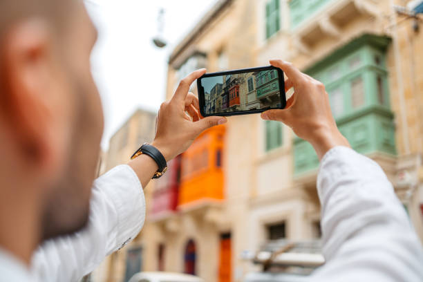 istock Young Man Taking Pictures Using His Smart Phone In Cospicua In Malta 1573692866