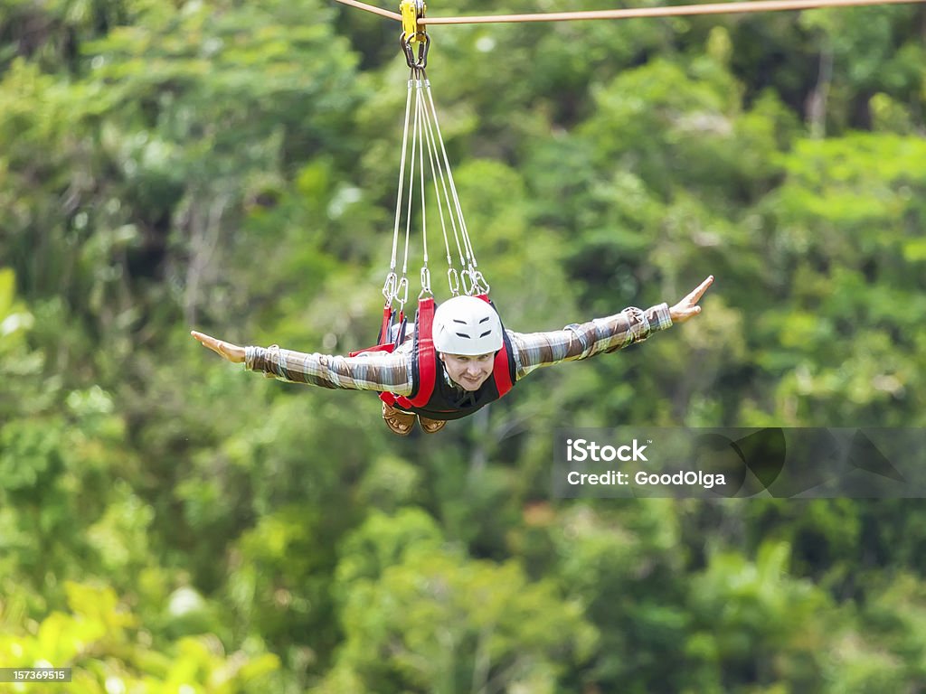 Zip-line Men enjoying zip-line flying over the forest Zip Line Stock Photo
