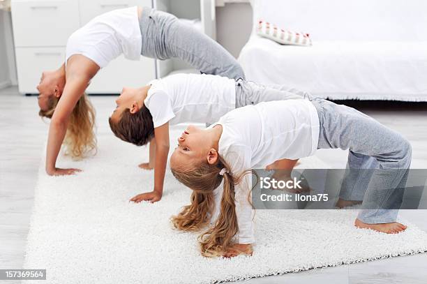 Woman And Kids Doing Gymnastic Exercises At Home Stock Photo - Download Image Now - Active Lifestyle, Activity, Adult