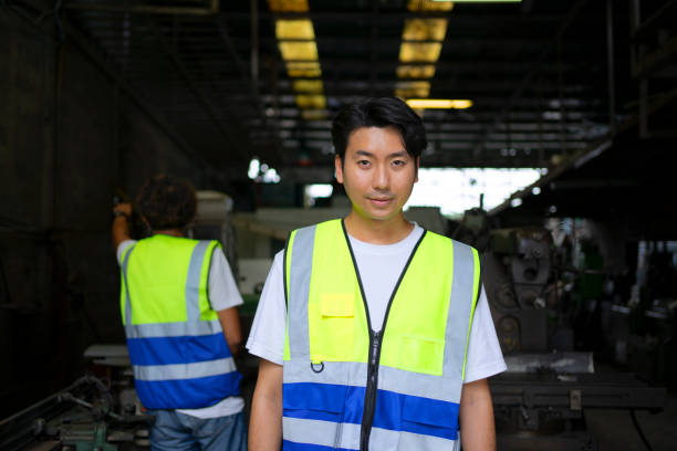 Blue collar workers are working at metal work factory. Engineering and co working concept.
