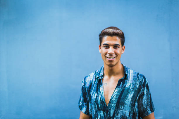 A guy joyfully posing in front of a blue background