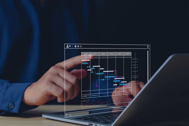 istock Businessman with work project and work improvement by planning progress and diagram on computer screen. 1573715782