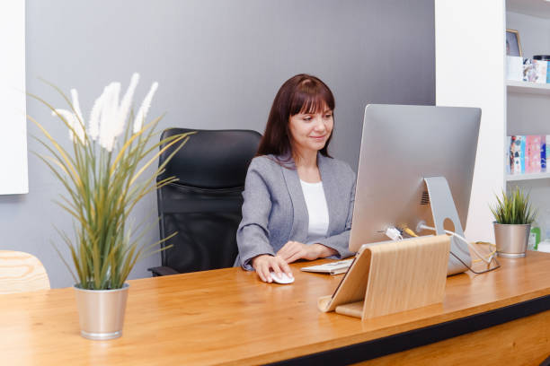 istock A brunette woman at a computer in the workplace. Business concept. 1573725832