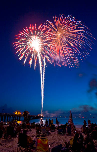 fuegos artificiales en la playa roja con ráfagas de luz de cielo - florida naples florida pier beach fotografías e imágenes de stock