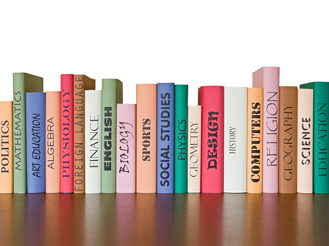 Many books stacked with blurred background of bookstore full of books. Photo with copyspace