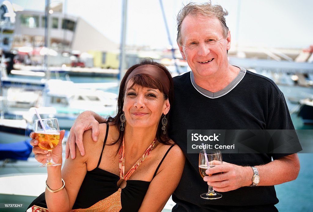 Happy Wealthy Mature Couple by the Sea Portrait of a wealthy mature couple sipping cocktail on their Mediterranean vacation, having fun with their lives. Photo taken in Gozo, Malta. 50-54 Years Stock Photo