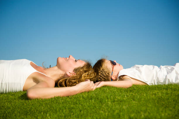 istock Mother and daughter lying on grass 157373269