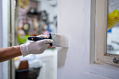 Close up of a man hand carefully painting the edge of an house window