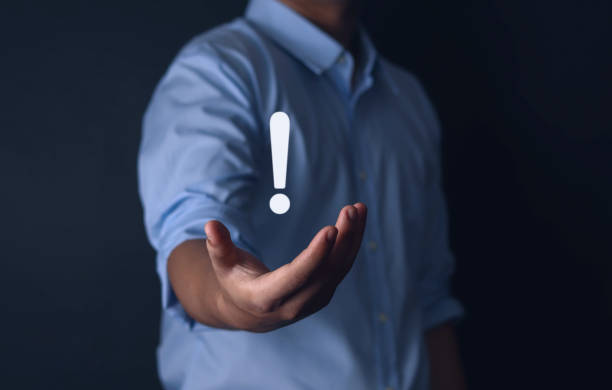 istock exclamation mark on businessman hand 1573735228