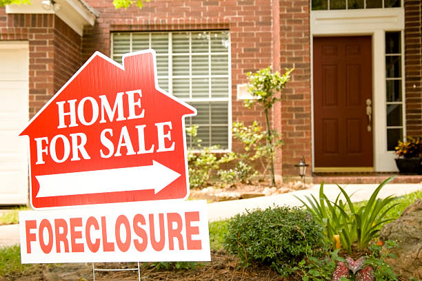 Real Estate Sign in yard of foreclosure house. For sale. stock photo