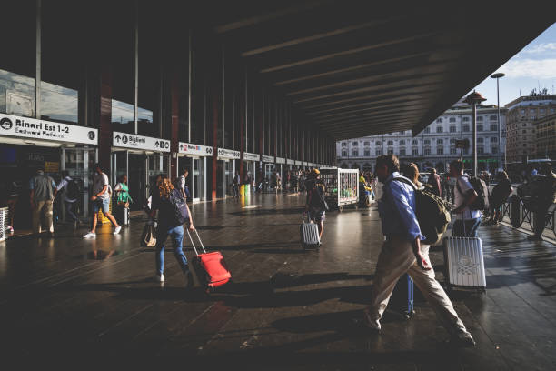 rzym, włochy. późnym popołudniem niektórzy ludzie z wózkami spieszą w kierunku wejścia na dworzec kolejowy roma termini, na piazza dei cinquecento. - cinquecento zdjęcia i obrazy z banku zdjęć