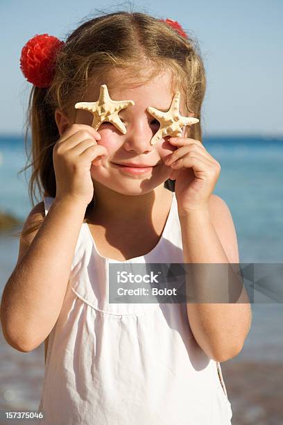 Foto de Menina Em Pé Na Praia E Mostrando Estreladomar e mais fotos de stock de 4-5 Anos - 4-5 Anos, Alegria, Criança