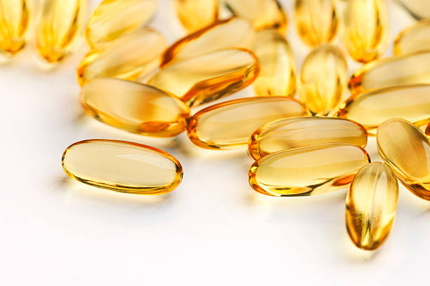 nahaufnahme von kapseln (siehe unten für zwei weitere versionen - cod liver oil fish oil vitamin e vitamin pill stock-fotos und bilder