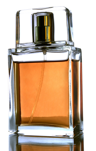 Bottle of perfume surrounded by different spices on white background, top view