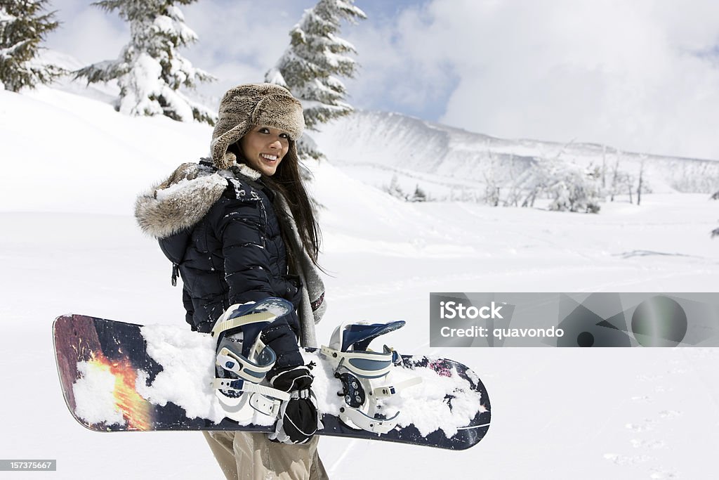 Joven mujer asiática mixto Snowboarding on nívea las montañas, espacio de copia - Foto de stock de Snowboard libre de derechos
