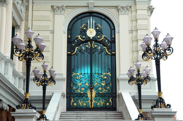 Deep blue painted double door entry of luxurious parisian home showing the  decorative stone exterior around it and shiny brass weatherstrip and door handles.