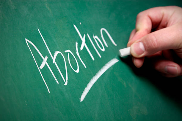 Chalkboard - Abortion A hand writes the word "Abortion" on a chalkboard. abortion photos stock pictures, royalty-free photos & images