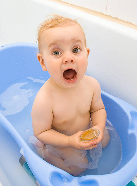 Baby singing in a bath stock photo