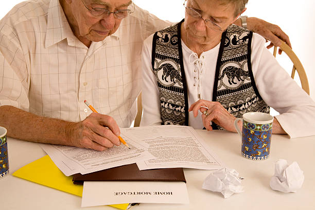 istock Mature couple with mortgage loan paperwork. 157377447