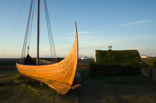 figurehead on the bow of a full-scale replica of a viking ship, moored in port