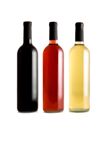Five small glass bottles on a white background. One bottle in the front has olive oil the others are empty.