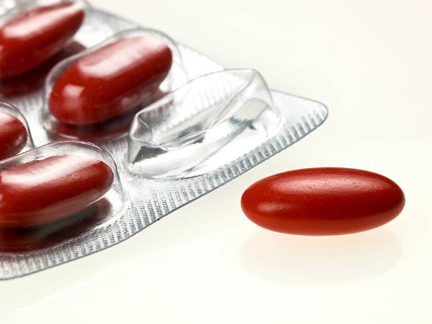 один красный таблетка из пузырь - capsule vitamin pill red lecithin стоковые фото и изображения