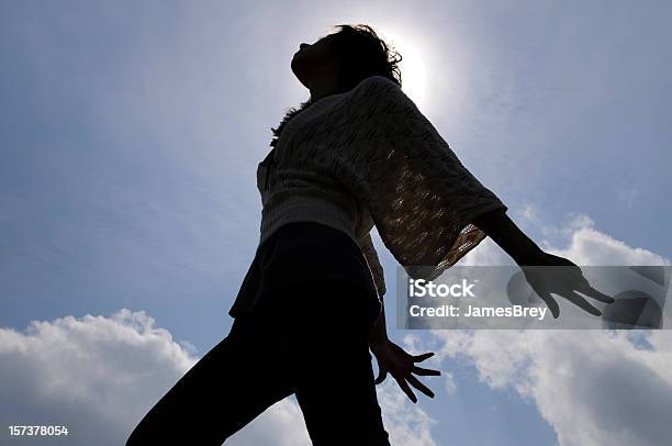 Photo libre de droit de Jeune Femme Danse Silhouettes De Soleil Ciel Bleu Et Fond De Nuages banque d'images et plus d'images libres de droit de Danser