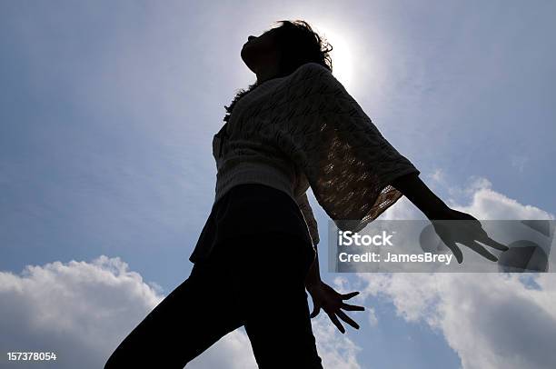 Young Woman Dancing Silhouetted By Sun Blue Sky Clouds Background Stock Photo - Download Image Now