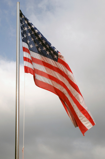 A photo of American flag waving against the sky symbolizing patriotism, freedom, and national pride