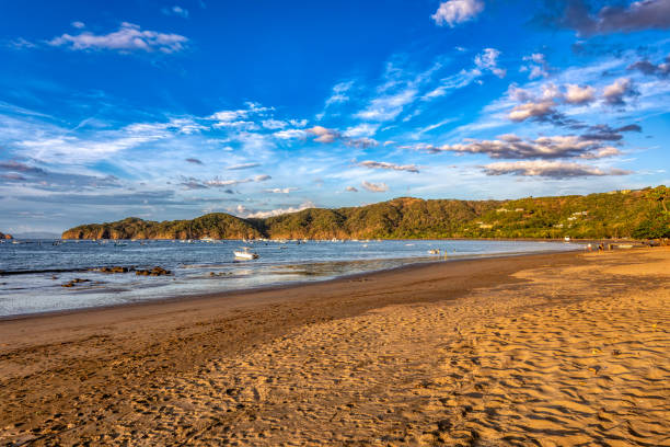 Evening view of the Pacific Coast, Del Coco beach with sunset and glittering waves . Idyllic sunset landscape. Coco Costa Rica. Pura Vida concept, travel to exotic tropical country.