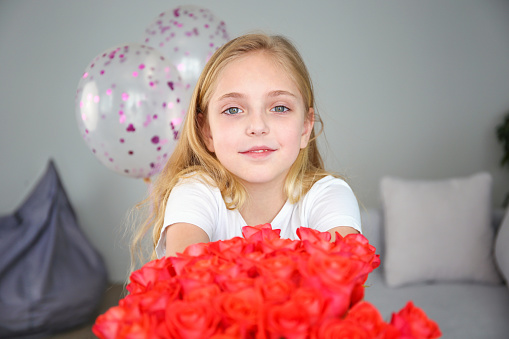 A girl with a smile gives a bouquet of flowers for Mother's Day.