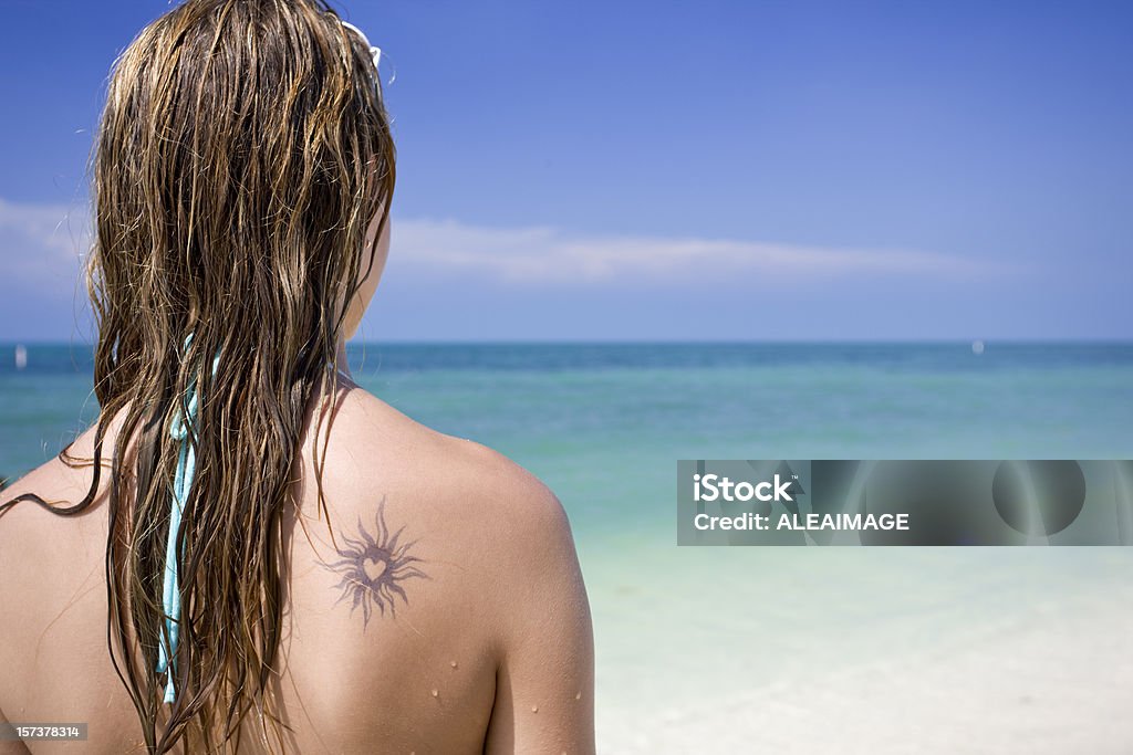 Girl looking at sea with tattoo in the back.  Heart Shape Stock Photo