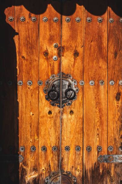 istock Vintage wooden door with intricate iron details including rivets and knobs. 1573783221