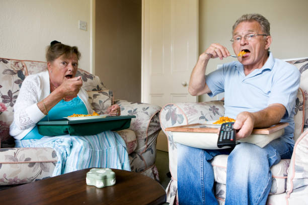 ruhestand: tv dinner - senior women electronics people remote control stock-fotos und bilder