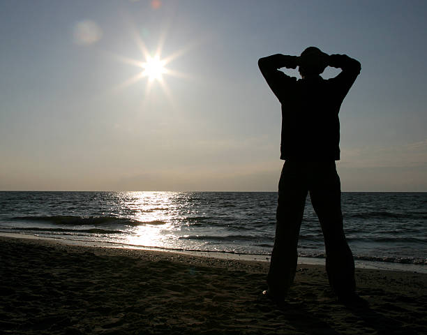 istock Silhouette of man relaxing  at the beach 157378560