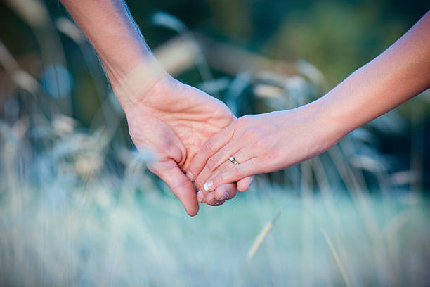 mężczyzna i kobieta z pierścionek z brylantem para trzymając się za ręce na zewnątrz - hands clasped copy space love outdoors zdjęcia i obrazy z banku zdjęć