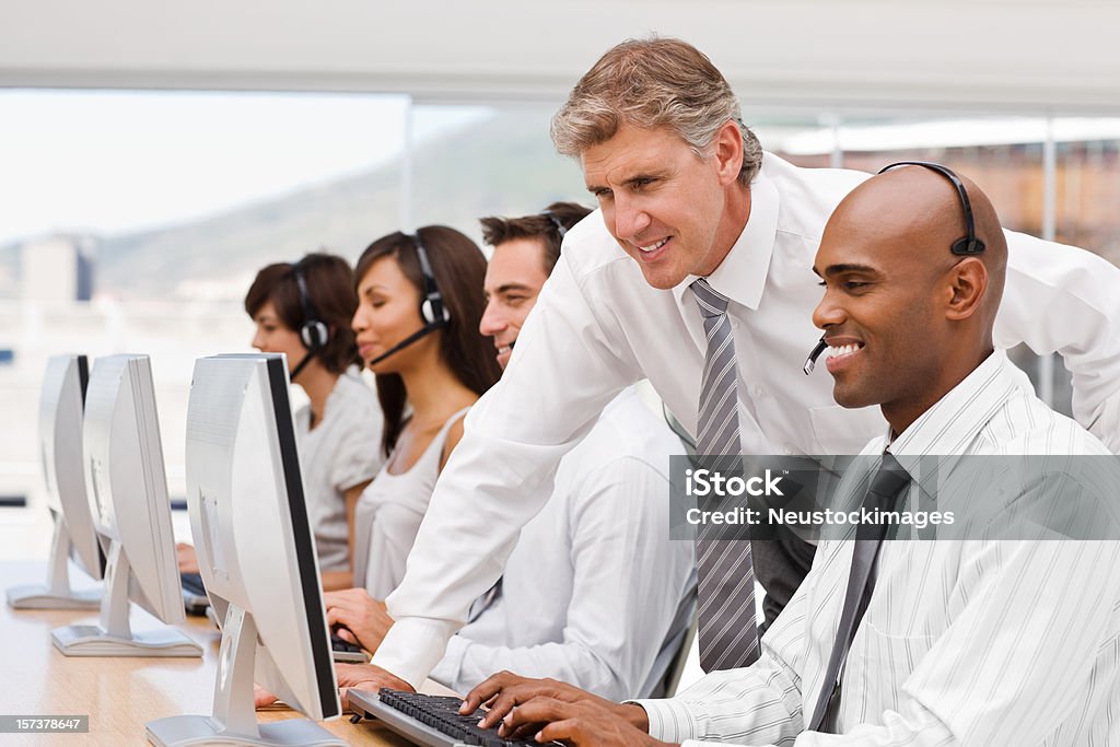 Felices empresarios trabajando en una computadora portátil - Foto de stock de Centro de llamadas libre de derechos