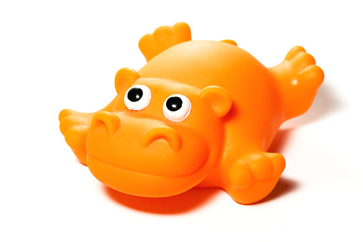 Portrait of a funny and smiling orange rubber hippo, isolated on white. Ideal for conveying any children and/or play related concepts.