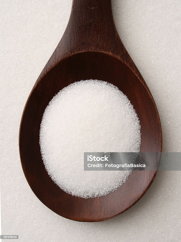 Sugar Top view of wooden spoon full of sugar Brown Stock Photo