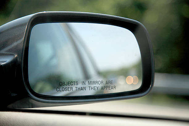Close-up of car mirror objects are closer than they appear message on the side view mirror rear view mirror stock pictures, royalty-free photos & images