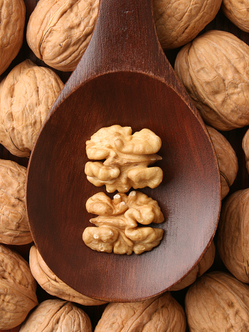Top view of wooden spoon with walnuts on it