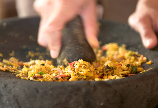 Grinding up Balinese spices with a traditional pestle and mortar.  Note: Selective focus and motion blur on the hands.