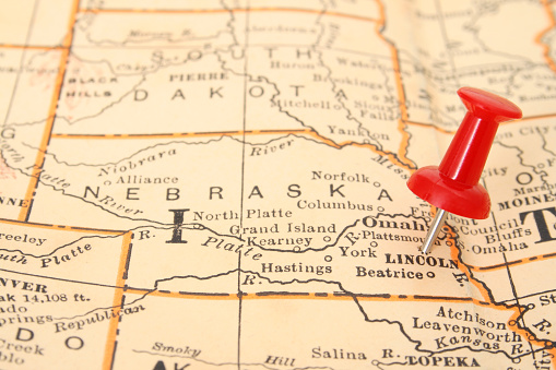 Pushpin pointing Lincoln city, Nebraska state capital, over more than fifty years old map