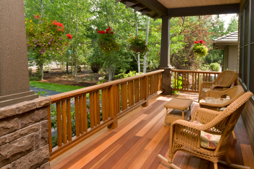 This multi colored hardwood front deck, with wicker chairs gives you a beautiful morning garden view. 