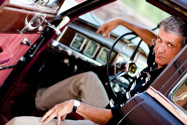 istock Man in old car portrait 157379642