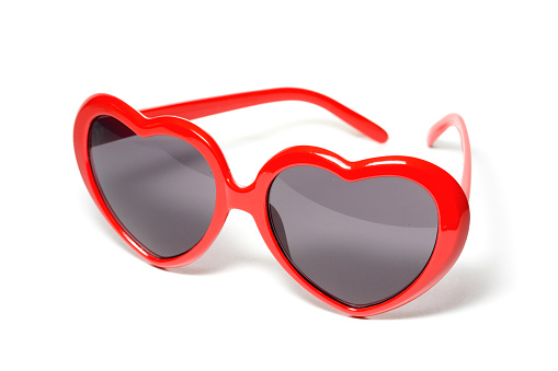 A wonderful and striking pair of red heart shaped sunglasses, isolated on white, which recalls the famous movie star's style.