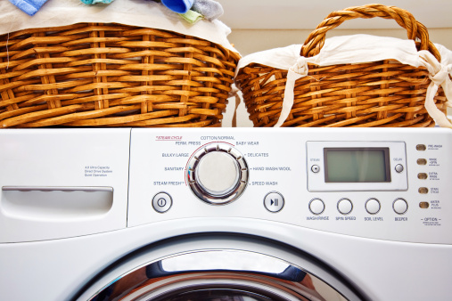 Washing machine with laundry baskets on top.
